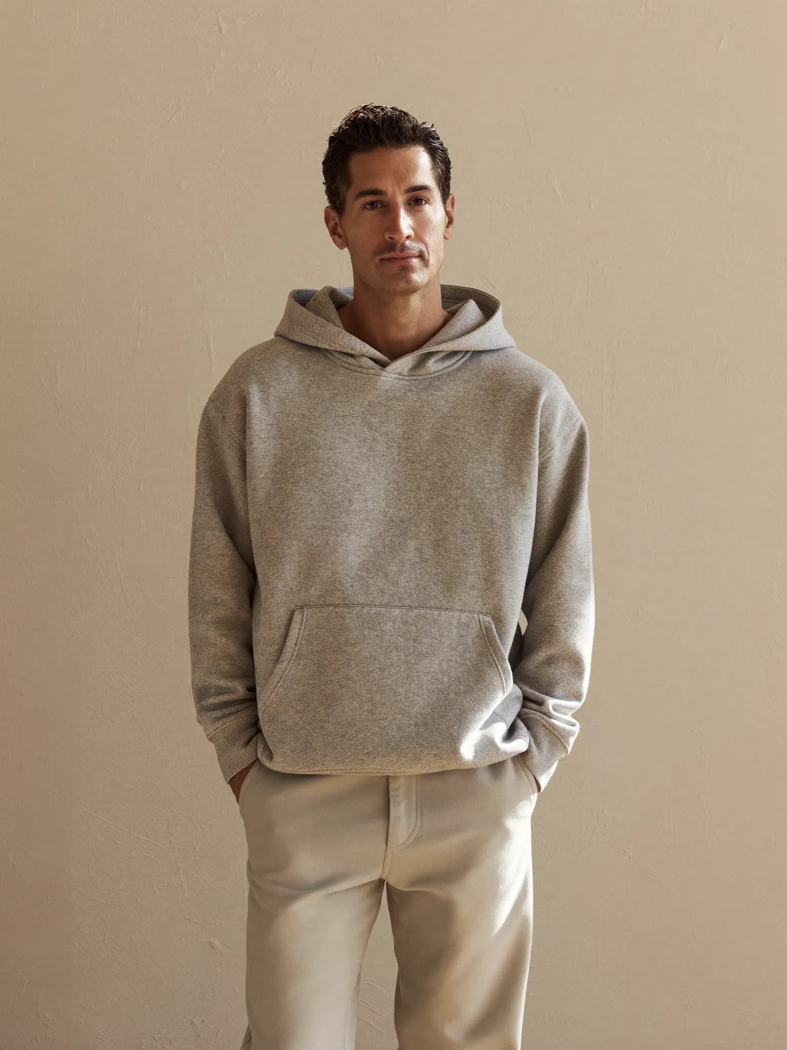 Model wearing the Heather Grey Heavyweight Pullover Hoodie.